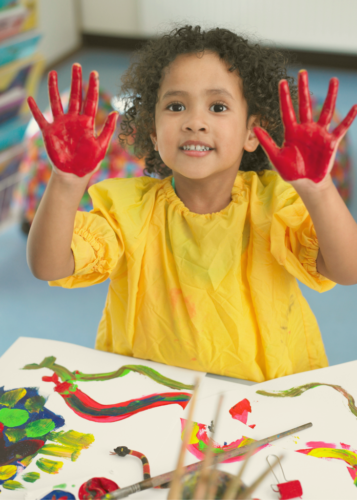 Child with red paint on hands