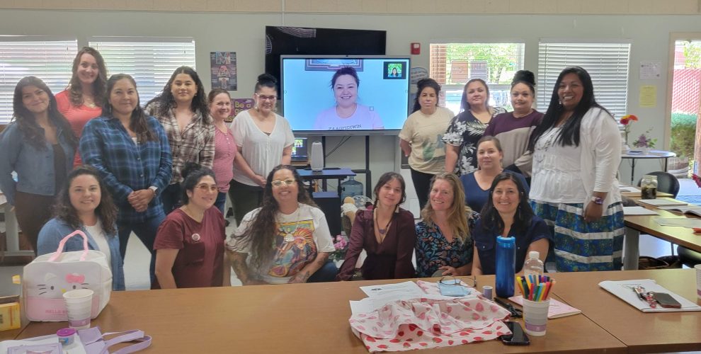 A group of 18 local people, most Indigenous People, stand and sit together around the trainer on a large screen who taught via Zoom. And the Mendocino Doula community grows with Indigenous Doulas.