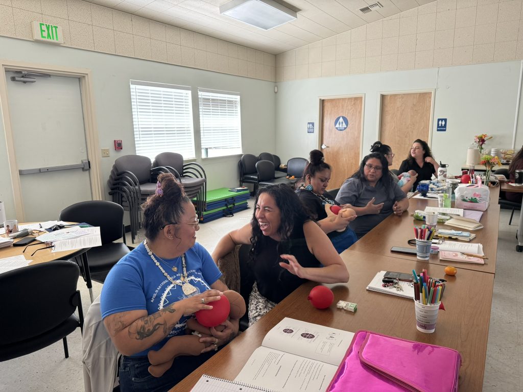 Doulas chat and practice supporting lactation in the Redwood Valley Rancheria Learning Center.